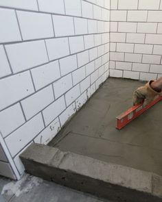 a man is laying concrete on the floor