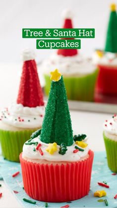 cupcakes decorated with christmas trees and sprinkles on a blue napkin