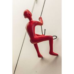 a red figurine hanging from the side of a wall