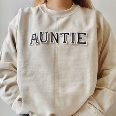 This unique and trendy beige Auntie sweatshirt is perfect for lounging in this cozy fall season! This is also perfect for gifting to your loved ones! The letters (patches) and are heat pressed. Our sweatshirts run in a UNISEX fit. The sweaters naturally have a slightly oversized fit giving extra room for moving around and comfort! For this reason, we highly recommend getting your true normal size especially if you like that slight oversized fit! :) We are currently offering sizes S-L. The materi Pregnancy Announcement To Sister Aunt, Motherhood University, Aunt Hoodies Sweatshirts, Auntie Embroidered Sweatshirt, Sibling Pregnancy Announcement, In My Auntie Era Sweatshirt, Aunt Baby, Auntie Sweatshirt