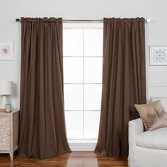 a living room with a white couch and brown curtains