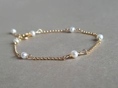 A dainty, elegant pearl and gold bracelet!  Please measure tightly your wrist's circumference, using a ribbon or something similar, and then measuring the ribbon with a ruler. When ordering, please select the actual wrist size, not the size of the bracelet. I will make the bracelet fit your wrist, by adding approx 0.6 inch to the circumference. The bracelet was set up using cultured pearls and gold filled findings it is adjustable. Available also in sterling silver or rose gold filled finish.  Pearls are a symbol of purity, faith, charity, innocence, integrity, focus, wisdom, spirituality, sincerity. Healing lore: Fertility, childbirth, digestion, muscular system. DISCLAIMER: Healing Gemstones are not a replacement for professional medical care. Materials: ~ culture pearls ~ gold filled/st Elegant Pearl Bracelet With Delicate Adjustable Chain, Elegant Adjustable Pearl Bracelet With Delicate Chain, Dainty Adjustable Pearl Bracelet For Formal Occasions, Feminine Gold Pearl Bracelet For Wedding, Elegant Yellow Gold Bracelet For Bridesmaid Gift, Dainty 14k Gold Filled Pearl Bracelet For Wedding, Adjustable 14k Gold-filled Elegant Pearl Bracelet, Adjustable 14k Gold-filled Pearl Bracelet For Wedding, Elegant White Pearl Bracelet 14k Gold Filled