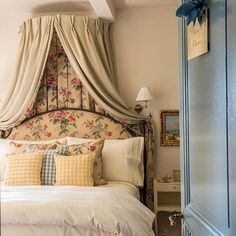 a bed sitting under a canopy in a bedroom