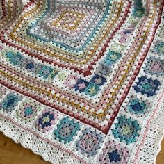 a crocheted blanket is laying on the floor