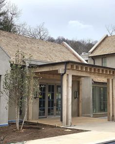 the front entrance to an apartment building with wood shingles on it's roof