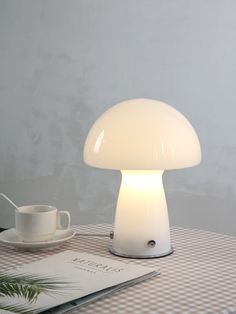 the mushroom lamp is next to a cup and saucer