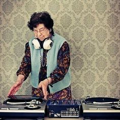 an old woman with headphones is playing music on her turntable and record player