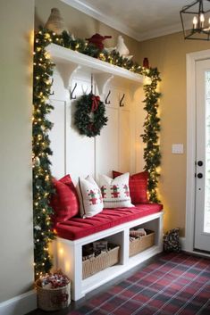 a bench with christmas wreaths and lights on it in front of a door way