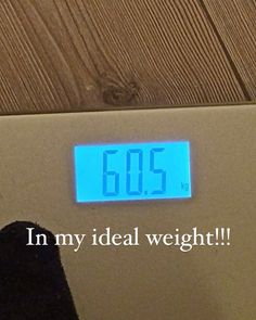 a person standing in front of a bathroom scale with the words 605 on it