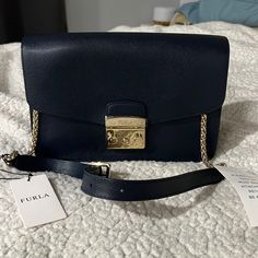 ***Brand New**** With Dust Bag. Still Has Tags. Beautiful Navy Purse With Gold Hardware. Even Has Plastic Sticker For The Hardware Never Used Chic Blue Shoulder Bag With Gold-tone Hardware, Elegant Navy Shoulder Bag With Gold-tone Hardware, Navy Leather Shoulder Bag With Gold-tone Hardware, Luxury Navy Shoulder Bag With Gold-tone Hardware, Navy Purse, Blue Crossbody Shoulder Bag With Gold-tone Hardware, Yellow Purses, Furla Bags, Brown Tote Bag