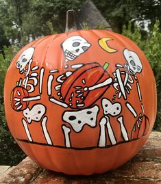 an orange pumpkin decorated with skeletons and skulls