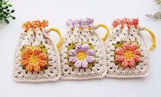 three crocheted bags with flowers on them