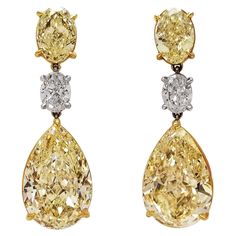 From SCARSELLI, world-renowned for investment grade natural fancy color diamonds, comes this 3 stones dangled earrings GIA certified: 2 matched pair Fancy Yellow pear shape of 8+ carat each, beautifully cut for dazzling brilliance, hanging from a totaling 1 carat oval F color diamonds VVS and VS clarity respectively. A matching pair of fancy yellow ovals 1.5 carat each at the top set on a platinum and 18k gold handmade setting to display these amazing Scarselli stones (see certificates pictures