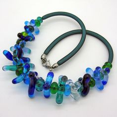 a necklace made out of glass beads on a green cord