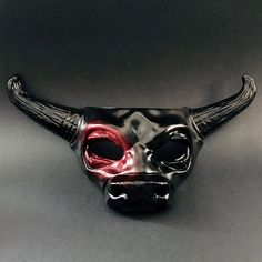 Experience the essence of strength and magnificence with our captivating bull mask adorned with striking bull horns. Step into the world of these majestic creatures, exuding their fearless spirit and commanding presence. This mask is the perfect addition to any masquerade outfit or Halloween costume! Age Group/Gender - Adult/Men Size/Type - One size fits all adults Mask Color - Black with colored eye Mask Material - Polyresin Horned Masquerade Mask For Halloween, Black Eye Mask For Fantasy Events, Black Horned Masquerade Mask For Costume, Black Horned Masquerade Mask, Horned Black Masquerade Mask For Halloween, Black Horned Mask For Masquerade, Black Horned Masquerade Mask For Costume Party, Bull Mask, Kids Party Packs