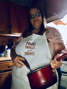 a woman in an apron holding a pot with the words food, family and friends on it