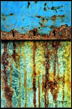 rusted metal with blue and yellow paint on it