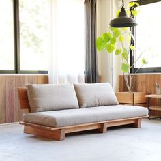 a living room filled with furniture and a plant in the corner on top of it