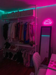 a closet with neon lights and clothes hanging on the shelves, along with a mirror