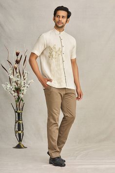 Beige linen shirt with animal embroidered motifs and mandarin collar.
Component: 1
Pattern: Embroidered
Type Of Work: Animal
Neckline: Mandarin
Sleeve Type: Short Sleeves
Fabric: Linen
Color: Beige
Other Details: 
Folk art embroidery
Closure: Front buttons
Note: Pant worn by the model is not for sale
Occasion: Resort - Aza Fashions Casual Short Sleeve Kurta For Festive Occasions, Festive Cotton Short Sleeve Shirt, Festive Short Sleeve Cotton Shirt, Casual Embroidered Short Sleeve Kurta, Traditional Embroidered Linen Shirt, Casual Cotton Shirt For Festive Occasions, Embroidered Linen Collared Shirt, Beige Linen Shirt, Folk Art Embroidery