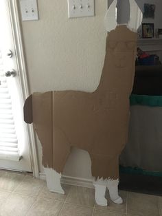 a cardboard llama standing next to a door