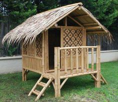 a small bamboo house with a thatch roof and stairs to the upper floor is made out of wood