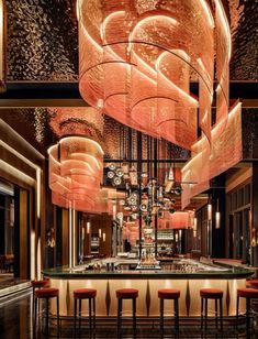 a bar with lots of stools and chandeliers hanging from it's ceiling