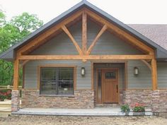 a house with stone and wood accents in the front yard