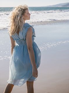 Ethereal and the color of blue skies and lapping waves. Our Goddess dress is light and airy with drawstring shoulder and ruched elastic empire waist detailing. 100% cotton deadstock cotton voile One Size S/M Chest width flat 18" Empire elastic waist flat 13", stretches to 19" Hip width flat 24" Body length from shoulder 42" Fully lined Hand wash cold, line dry, or dry clean Consciously made in small batches in sunny California using deadstock fabrics and recycled materials. Seasonless essentials Summer Empire Waist Maxi Dress With Gathered Neckline, Summer Maxi Dress With Gathered Neckline And Empire Waist, Beach Dress With Empire Waist And Ruffles, Beach Dresses With Ruffles And Empire Waist, Light Blue Ruched Bodice Dress For Summer, Light Blue Summer Dress With Ruched Bodice, Light Blue Ruched Bodice Summer Dress, Blue Summer Dress With Ruched Bodice, Beach Empire Waist Ruched Maxi Dress