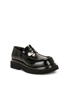 Find BOTTEGA VENETA Lug Loafer Gloss Vinyl on Editorialist. Bottega Veneta Lug Loafer Gloss Vinyl in Black Calfskin leather upper with lug rubber sole. Made in Italy. Penny strap at vamp. Glossy finish. Round toe. Approx 40mm/ 1.5 inch platform Approx 25mm/ 1 inch heel. BOTT-MZ98. 730222-V28R0-1000. About the designer: Bottega Veneta – inspiring individuality with innovative craftmanship since 1966. Creativity lies at the heart of all that we do. Born in Vicenza the house is rooted in Italian cu Black Calf Leather Loafers For Fall, Designer Leather Sole Loafers For Fall, Designer Fall Loafers With Leather Sole, Designer Leather Loafers For Fall, Designer Loafers For Business In Fall, Designer Black Platform Loafers For Work, Designer Leather Platform Loafers With Leather Sole, Black Calf Leather Platform Loafers For Work, Designer Fall Loafers For Workwear