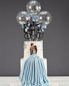 a blue and white cake with balloons on top