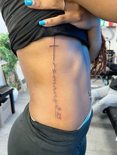 a woman with a cross tattoo on her lower back