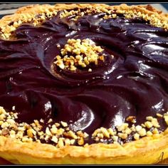 a chocolate pie with walnuts on top is ready to be eaten and served for dessert