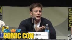 a man sitting at a table in front of a microphone