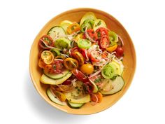 a yellow bowl filled with lots of different types of veggies on top of each other