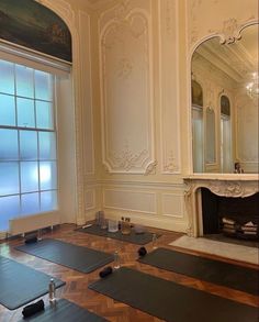 yoga mats laid out on the floor in front of a large window with a fireplace