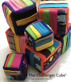 a pile of multicolored cubes sitting on top of a white table next to each other