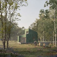 two people standing in front of a green building surrounded by trees and grass with bluebells