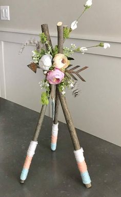 an arrangement of flowers and sticks on a table