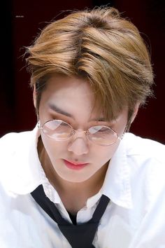 a young man wearing glasses and a tie