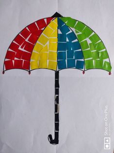 an umbrella made out of colored paper on top of a piece of paper with scissors