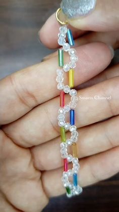 a hand holding a multicolored beaded bracelet