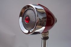 a close up of a red speaker on a metal pole