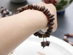 a close up of a person's arm holding a bracelet with beads on it