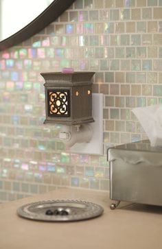 a bathroom with a sink and mirror next to a wall mounted toilet paper dispenser