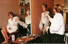 three women sitting in front of a mirror with their hair combed and makeup applied