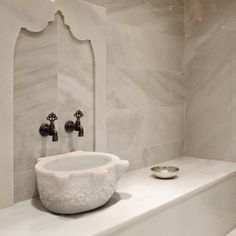 a white sink sitting on top of a counter next to a faucet