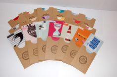 six brown paper bags with different designs on the front and back, sitting on a white surface