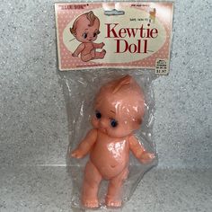 a small plastic doll with blue eyes in a package