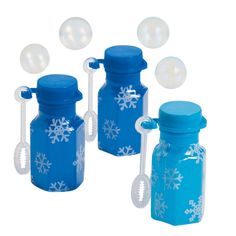 three blue glass bottles with snowflakes on them and spoons in the bottom